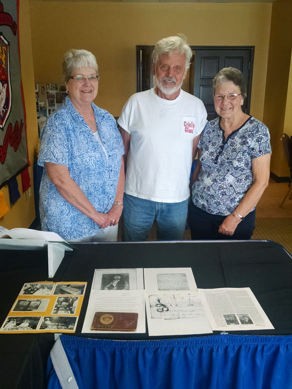 Ned, Louise, and Marie reviewing memorabilia
